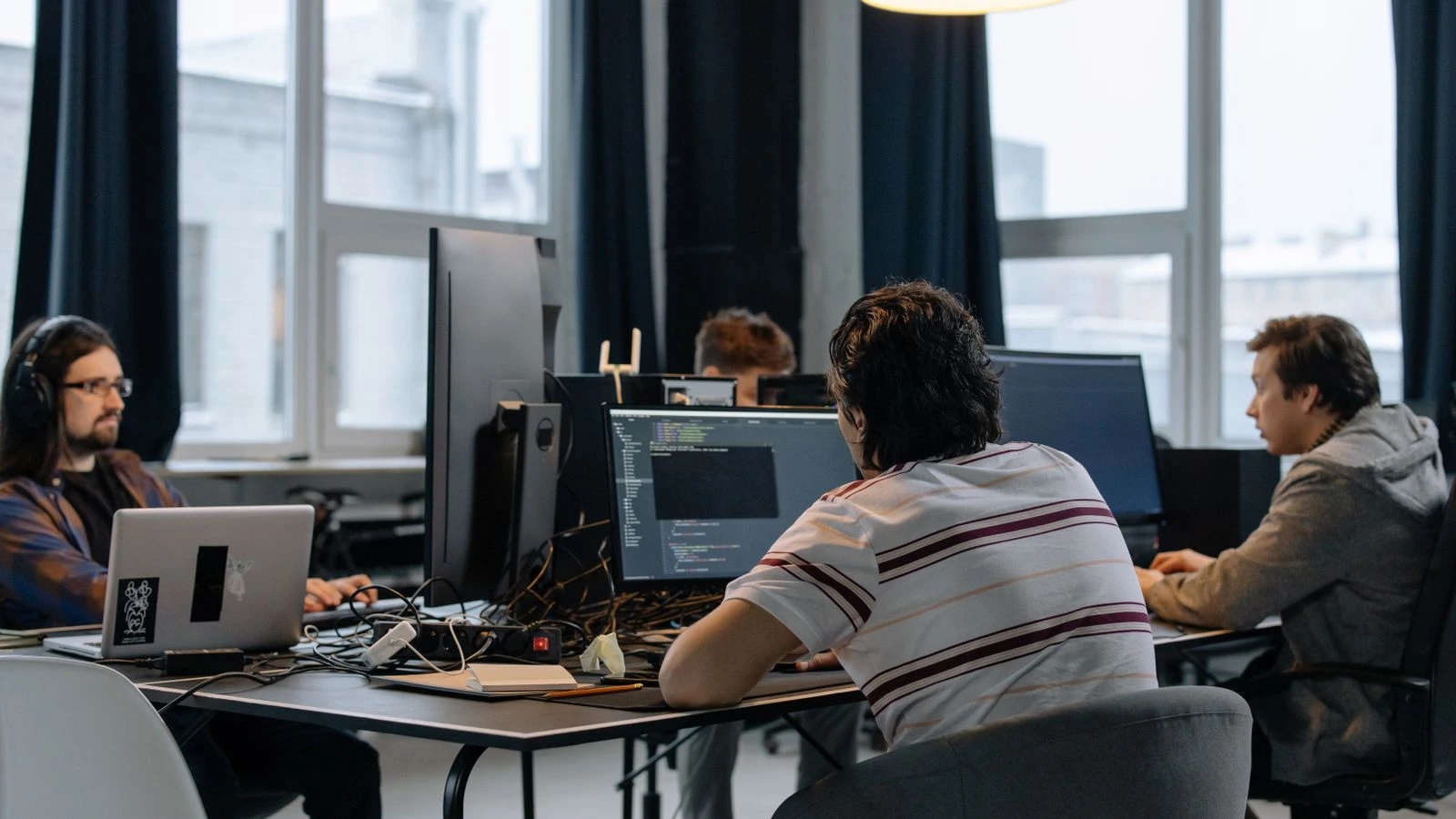 Team of developers working together on computers in a modern tech office