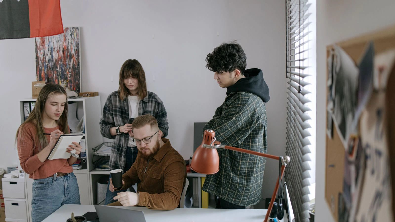 Group of professionals having a team meeting around a laptop in a modern startup office